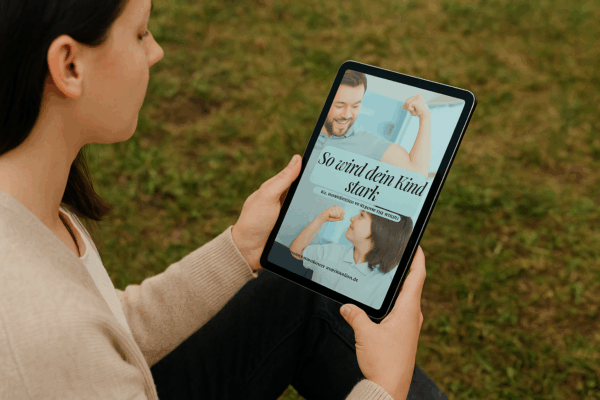 KI-generierte Frau, die ein Tablet in der Hand hält auf dem sie das E-Book "So wird dein Kind stark" steht.